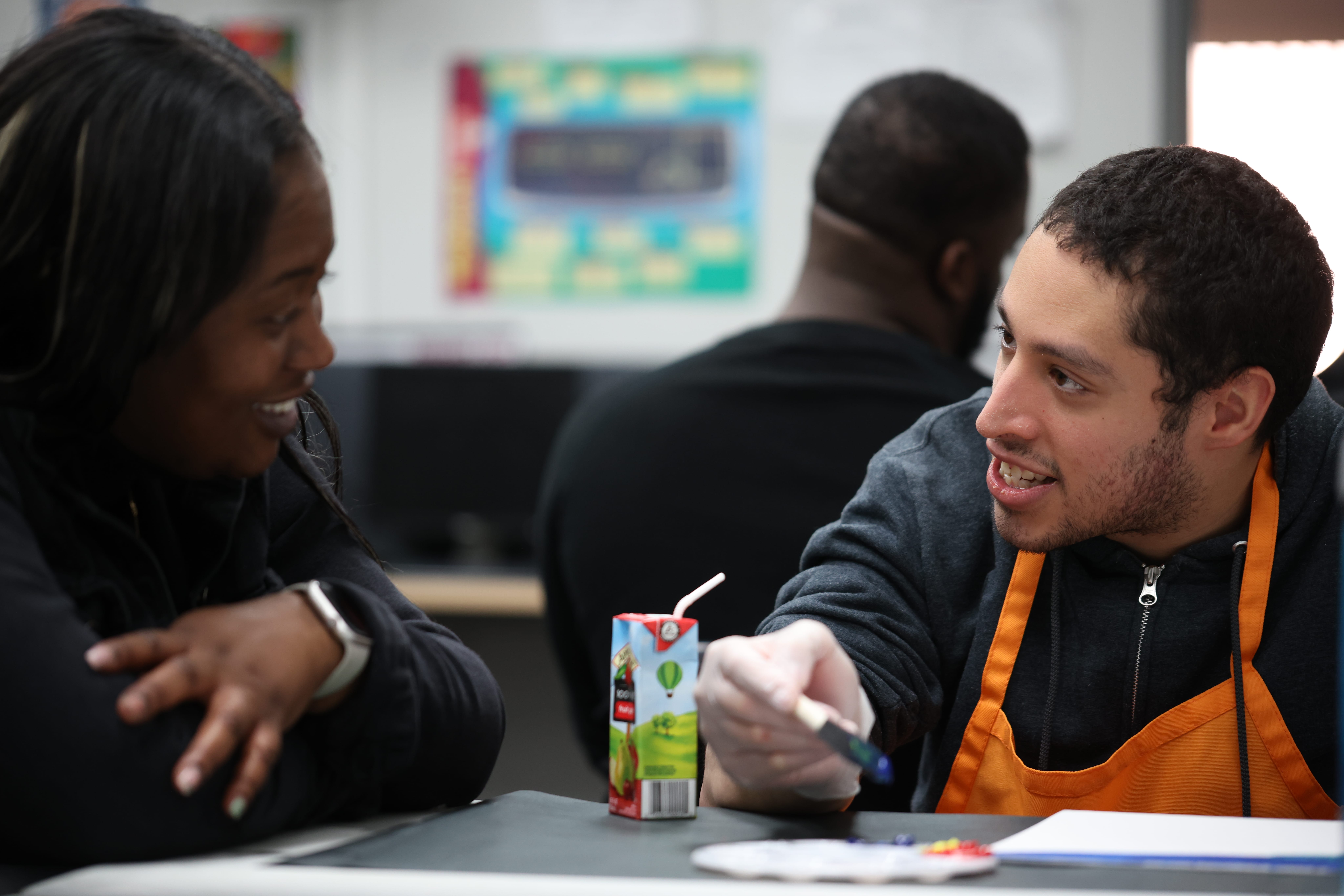 A direct support professional converses with a program participant.